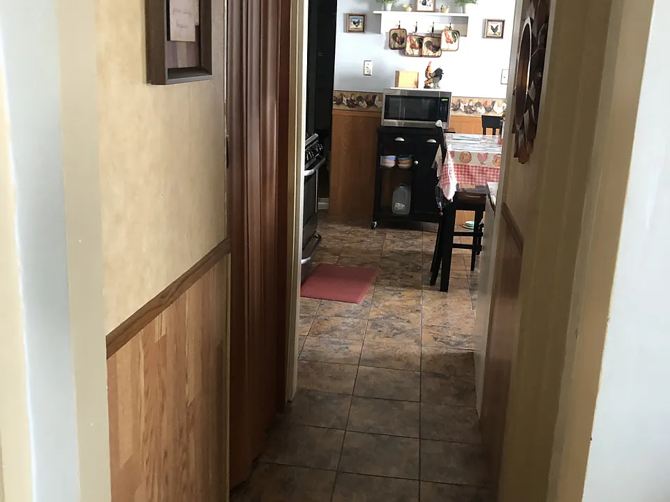 Hallway with bath off right side and pantry with washer hookup off left side