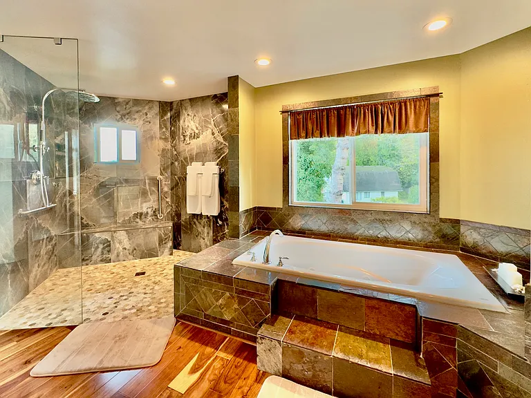 Luxurious bath featuring a walk_in shower, jacuzzi tub, and heated floors