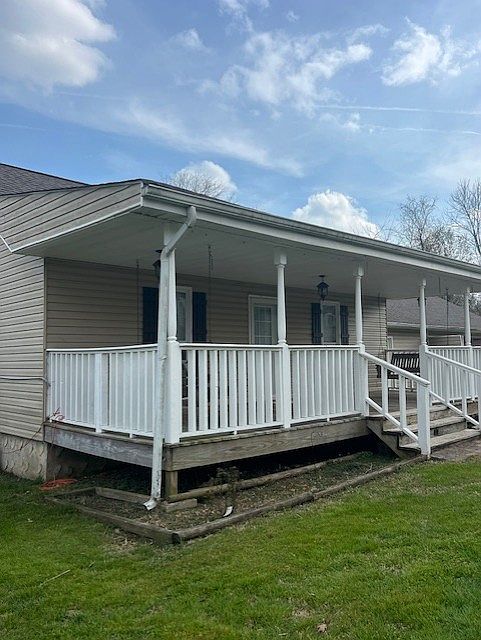 This property has a large front porch with two porch swings. It also has a small covered back porch