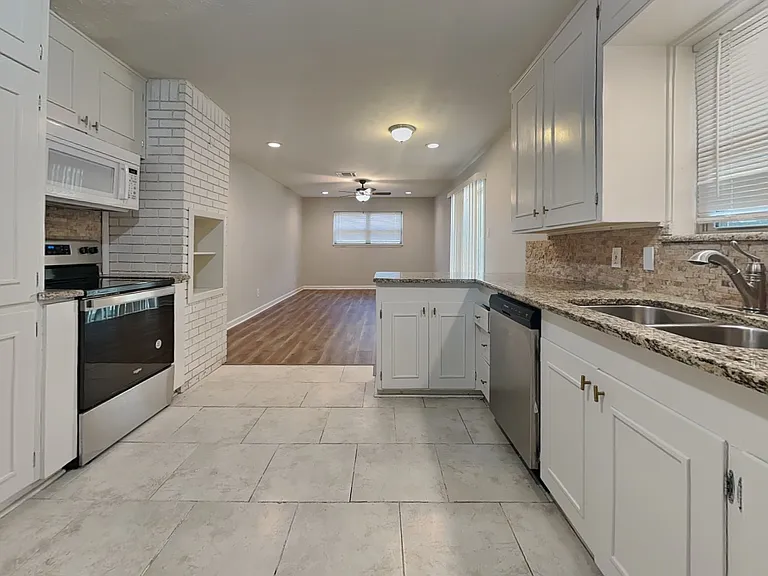 Spacious kitchen with white ca