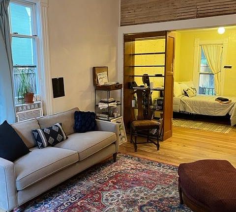 View from the spacious front room. Shows 11 ft. high ceilings. Cool exposed lathe wall. Bedroom.