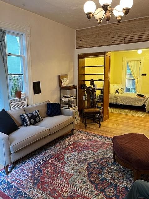 View from the spacious front room. Shows 11 ft. high ceilings. Cool exposed lathe wall. Bedroom.