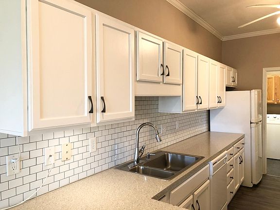 Kitchen with pantry, dishwasher, electric range, refrigerator and microwave.