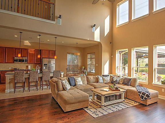 Soaring Windows in the Large Family Room Show Views of the Pool & Grand Covered Patio.  It is Open to the Kitchen & Breakfast Room. The Staircase to the Left of This Room Features Wrought Iron Ballusters.
