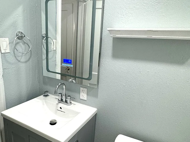 Bathroom with LED mirror and Bluetooth speaker, dimmable lighting and a new rollout casement window.