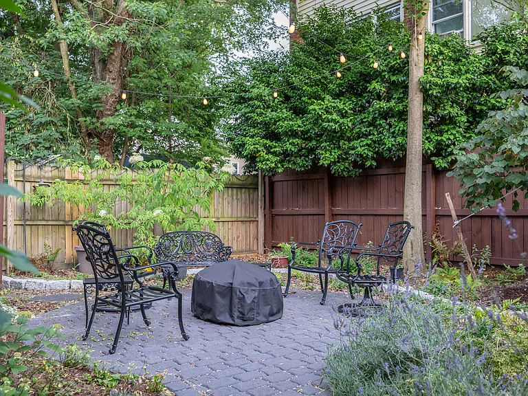 Back yard with firepit and twinkle lights.