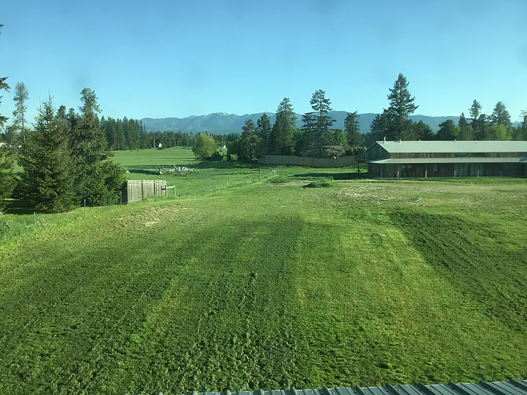 Breathtaking views of Whitefish Mountain Resort rise beyond the lush Montana landscape, creating a peaceful and romantic setting where endless skies and natural beauty surround you from the back porch.