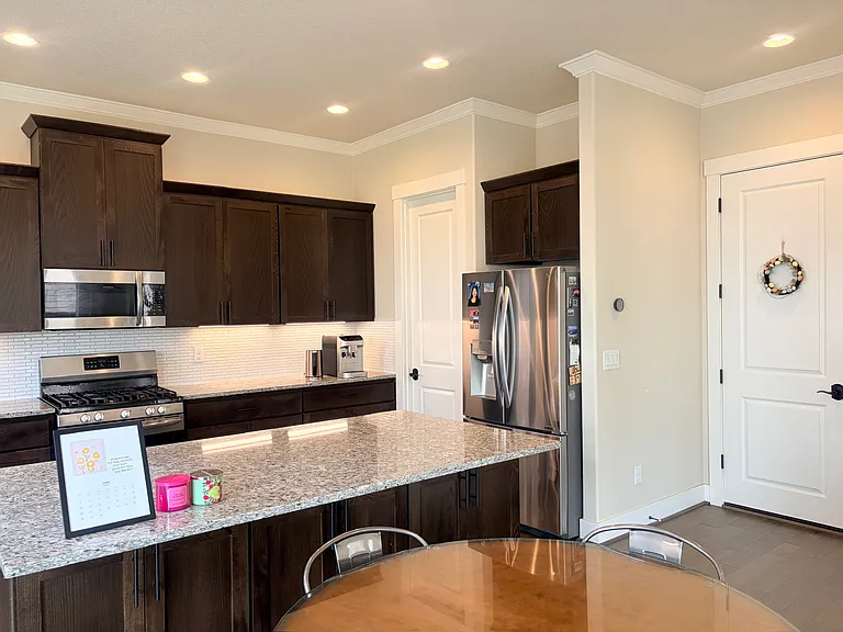 Kitchen view with island, pantry, and direct garage entry.