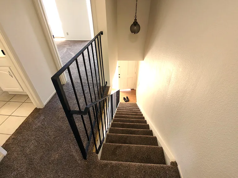View down the stairs, from the doorway of primary bedroom. Bathroom is to the left, 2nd bedroom is up left.