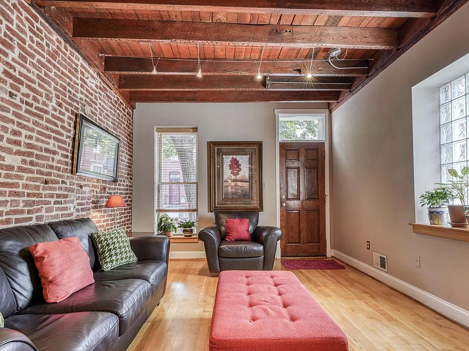 Living room with exposed brick and ceiling.