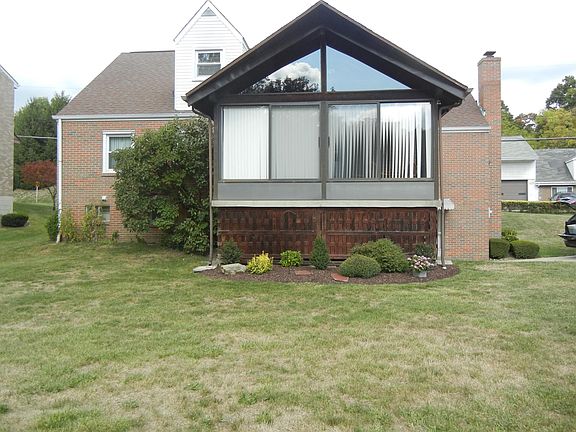 Back of home and sun room from very large yard