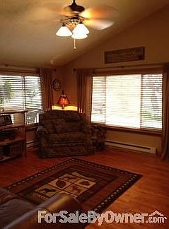 View of living room.
						:
						Neutral walls, hard wood floors, large windows and cathedral ceilings.