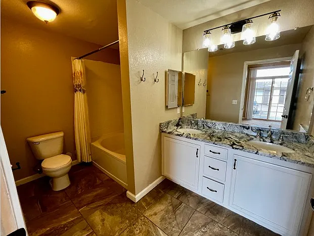 Ensuite bathroom for first bedroom, with double vanity and granite countertops.