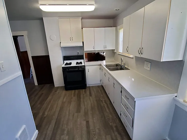 Kitchen with natural gas range and oven. Pass through to dining room next to stove.