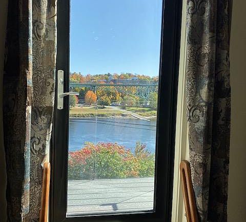 Door, in living room, to balcony and river view.