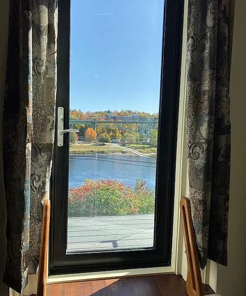 Door, in living room, to balcony and river view.