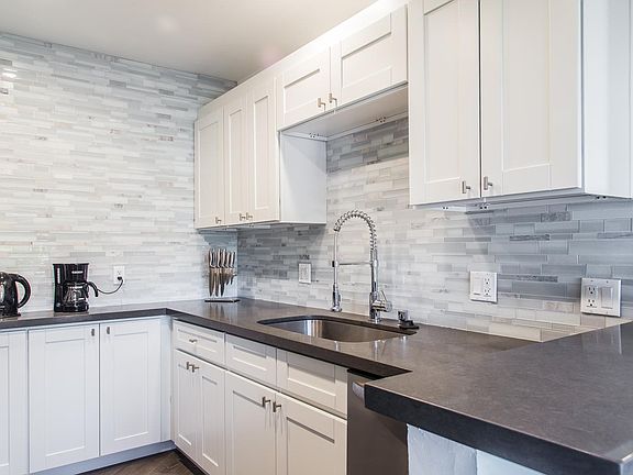 Absolutely gorgeous kitchen with the entire visible walls covered with elegant backsplash.