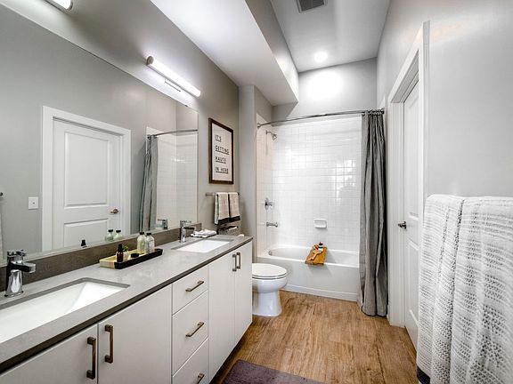 Bath with white cabinetry, grey quartz countertop, and hard surface flooring (Representative photo)