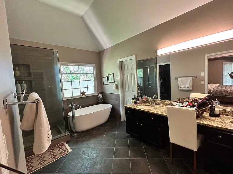 Spacious master bathroom featuring a soaking tub, separate modern shower, and abundant natural light.
