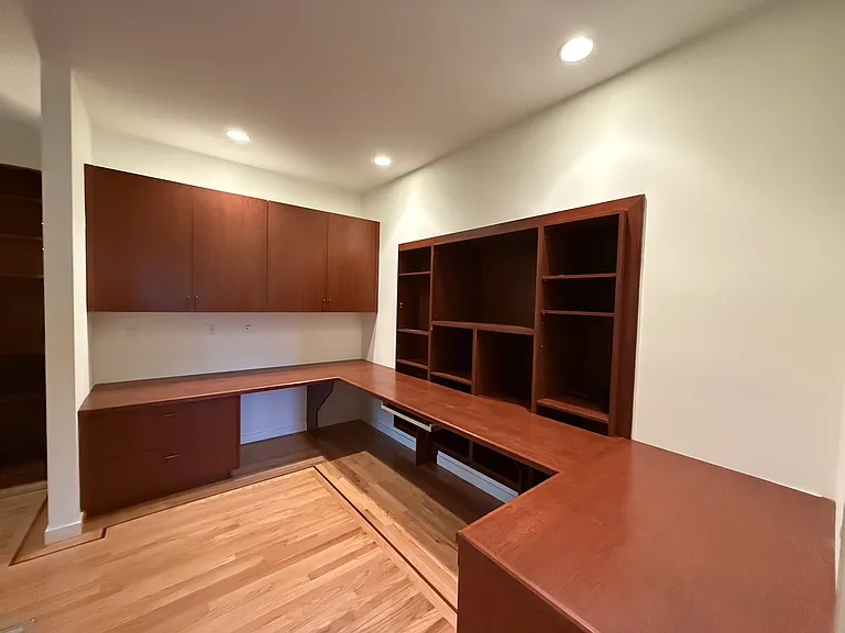 Private office features a built-in wall desk and library cabinetry.