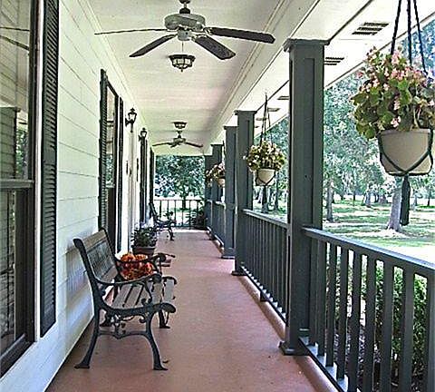 As you come up the walkway you are greeted by this pretty porch that is covered & extends the whole length of the house.  In addition, the concrete is painted giving it a burst of color and the ceiling fans make it an enjoyable place to sit & relax.