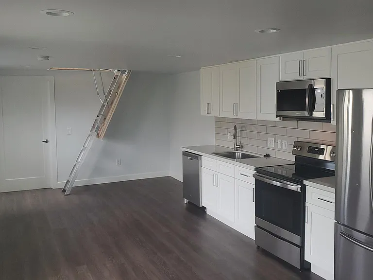 The living/dining/kitchen is undivided, with access to the attic bonus room.