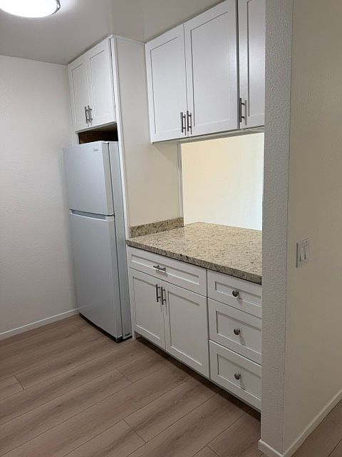 The other side of the kitchen with brand new refrigerator and bar seating