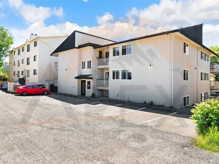 Exterior view of the apartment building with on-site parking area.