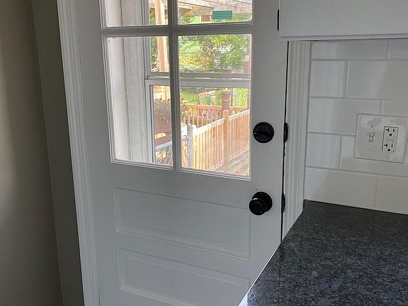 Back door in the kitchen to a small fenced yard and wood deck perfect for entertaining. It backs up to a grassy lot and no houses across the way.