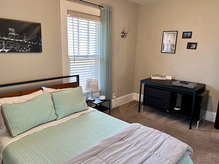 Guest room. Full bed, small dresser. Blinds and curtains.