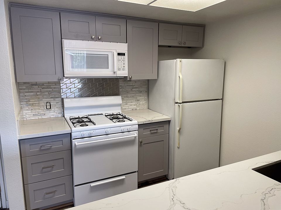Beautifully renovated kitchen with modern stainless tile backsplash, stone countertops, new cabinets, new appliances, etc.