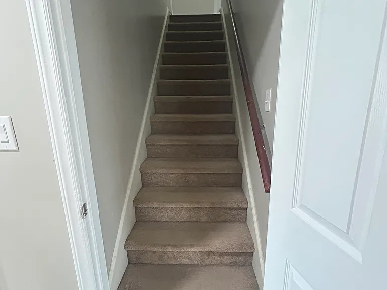 Stairs leading to loft to the right, and a bedroom with bathroom to the left