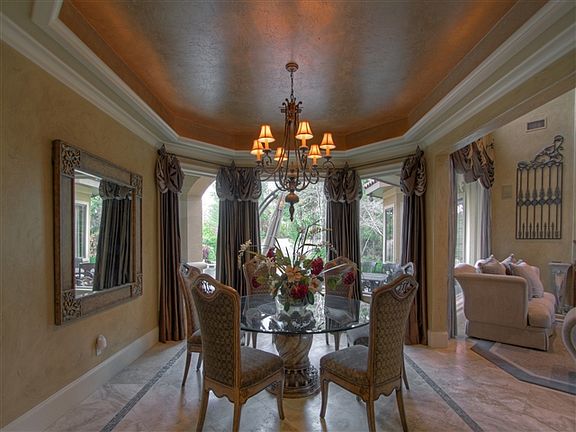 The formal dining room features a trayed ceiling with recessed lighting