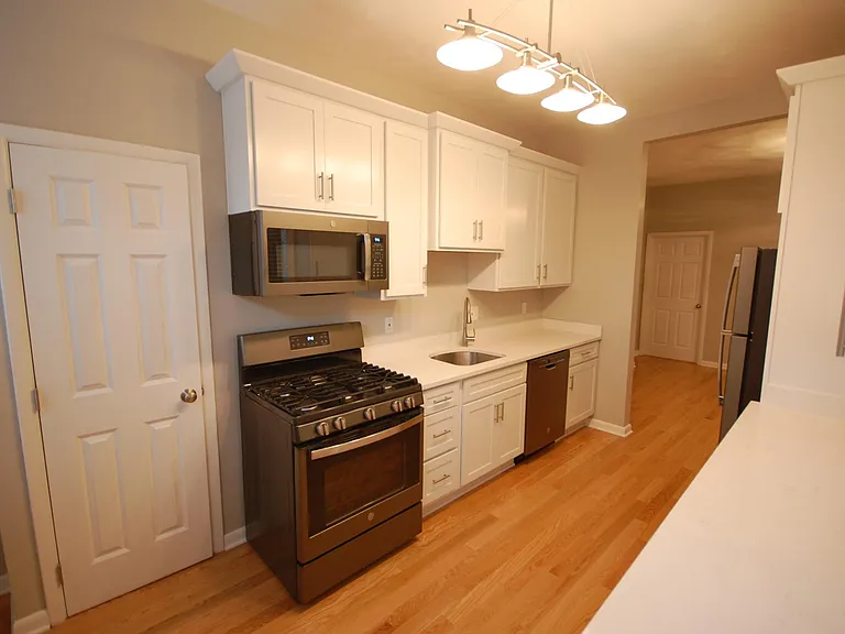 Renovated kitchen with quartz counters and stainless steel appliances