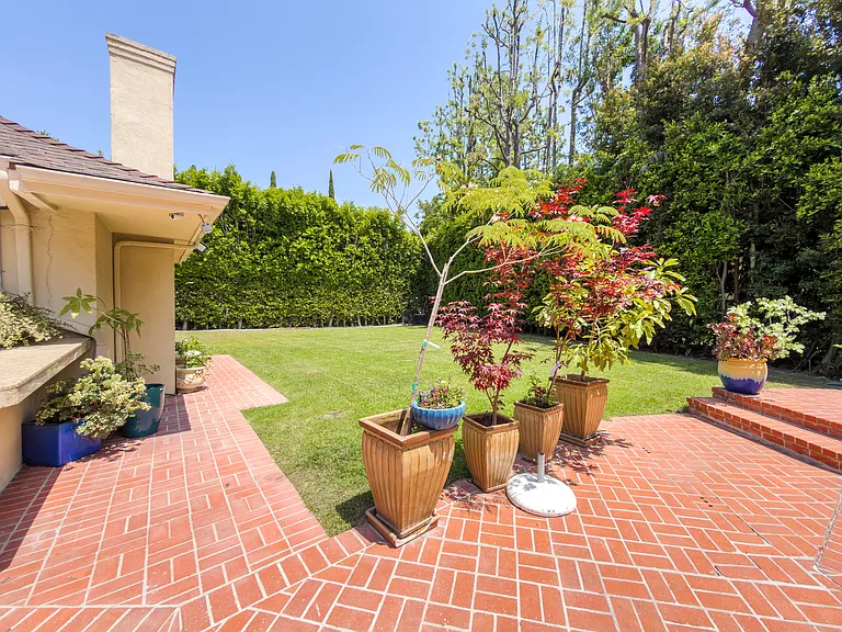 Charming brick side patio with potted plants adds outdoor character to this Beverly Hills luxury rental at 1094 Garden Lane, 90210.