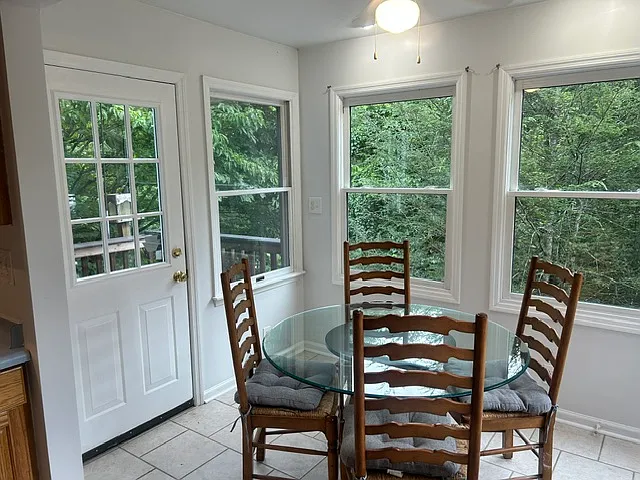 Eat-in kitchen area surrounded by windows letting in the morning sun