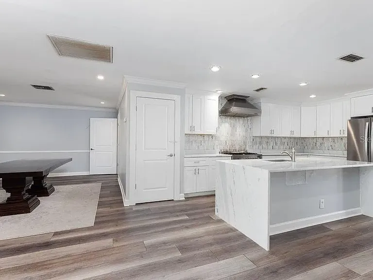 Beautiful marble waterfall countertops on a large kitchen island.