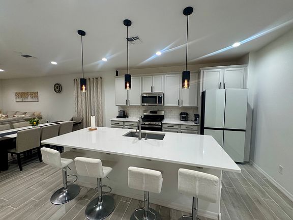 Stunning kitchen with large island, quartz countertops, modern pendant lighting, and Samsung Bespoke Refrigerator