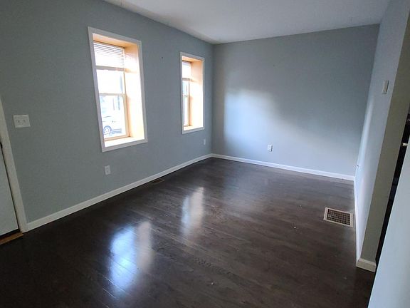 Spacious living room with hardwood floors, central air conditioning