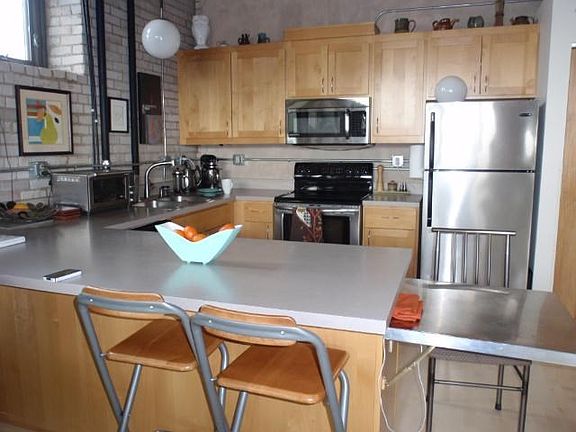 WHERE ART MEETS FUNCTION Stainless kitchen,high ceilings,with eat-on/serve-off counter along dining area.