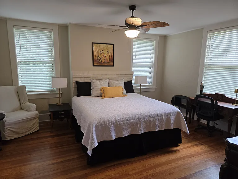 Front bedroom on main floor, with new king sized bed, writing desk. beautiful hardwood floors with door to shared jack and jill bathroom and lots of natural light, full length mirror and large dresser.