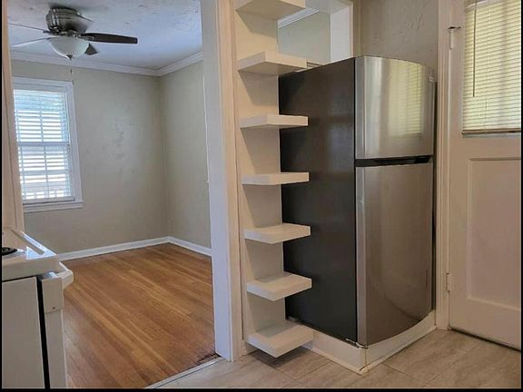 Kitchen Refrigerator area , shelves door with window to outside beautiful tries in back yard