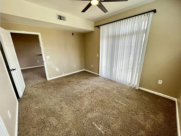 Second bedroom with sliding glass door leading to second porch area.