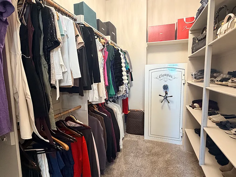 Hers walk-in closet with built in safe