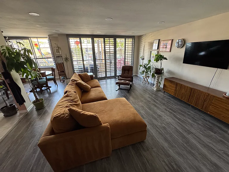 Living Room with fireplace to viewer's back. Not the floor-to-ceiling exterior windows leading to the unit's first-floor balconey.