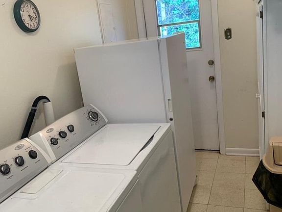 Laundry room with washer, dryer, and upright freezer.