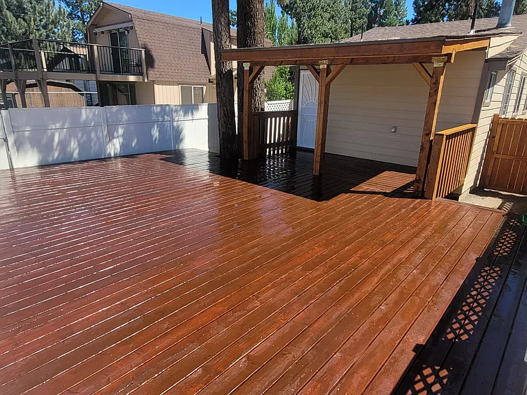 Backyard with full with full fence and remodeled deck.