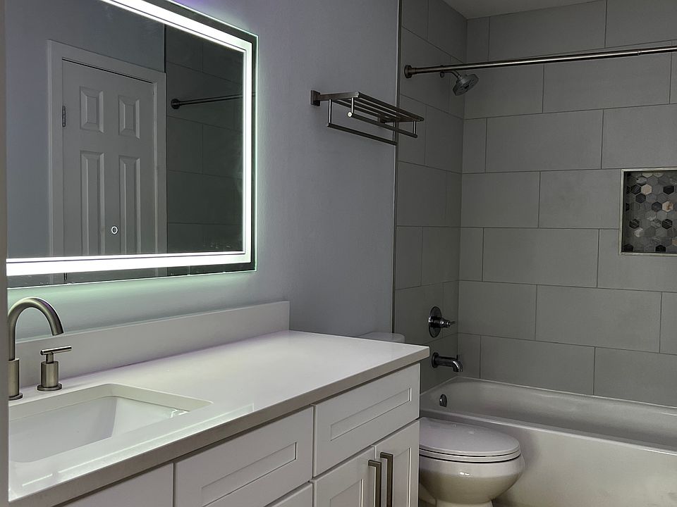 Bathroom with LED mirror, upgraded toilets, large vanity, and tiled shower