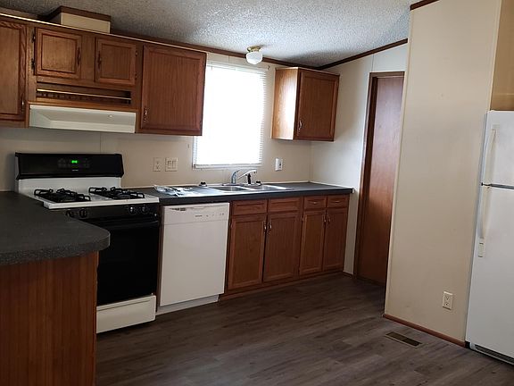 Kitchen showing gas range, dishwasher and laundry door