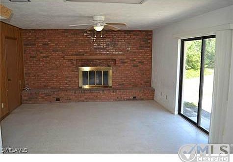 Family Room w/ Wood-Burning Fireplace & Glass Sliders to Open Pa